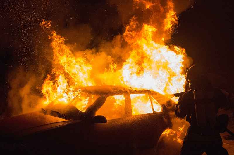 Firefighter extinguishing car blaze during emergency safety certification courses drill